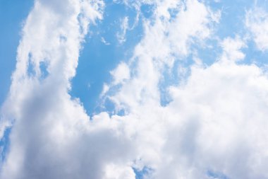 Mavi gün ışığı gökyüzü ve beyaz tüylü kümülüs bulutları