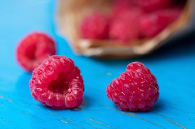 Kalp şeklinde kırmızı ahududu, ahududu aşkı konsepti. İştah açıcı bahçe meyveleri, yaz güneşi.
