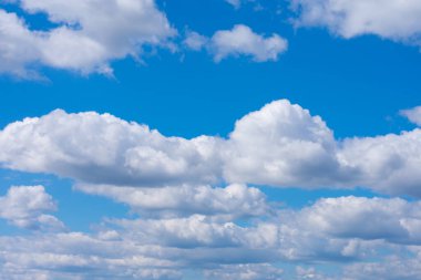 Parlak mavi gökyüzünde kümülüs olarak da bilinen birçok beyaz tüylü bulut. Bulutlu, bulutlu.