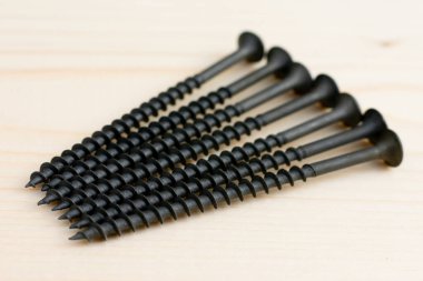 Tahta arka planda spiral ile uzun süre kendi kendine vuruşan vidalar. Aletleri tamir edip onarıyorum. Profesyonel ve DIY ekipmanları