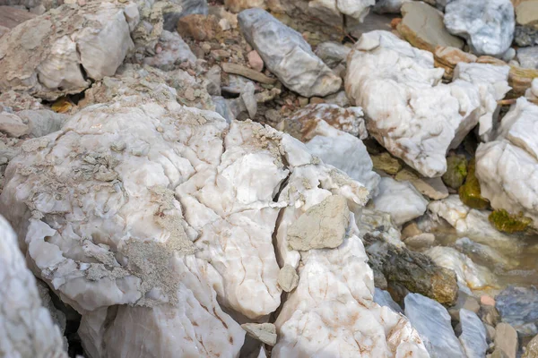 Large gypsum rock or stone surrounded by water. Big wet calcite washed in the river shore with lots of waves. Semi Precious white gem deposit or mining