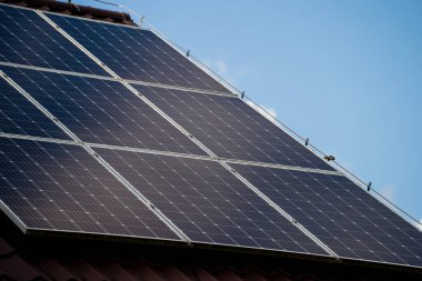 Tek bir aile evinin çatısına monte edilmiş güneş fotovoltaik paneller, konut elektrik üretimi için yenilenebilir enerji konsepti. Temiz enerji, sürdürülebilirlik ve modern ev altyapısı.