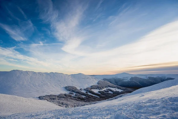 Karlı tepeler ve soğuk yürüyüş koşulları sırasında Tarnica 'dan görülen Bieszczady Dağları' nın uzak tepeleri ile mavi saat gündoğumu sırasında dağ manzarası.