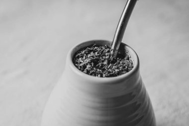 Yerba seramik bir kapta metal bombilla ile desenli, dengesiz bir arka planda eşleşir. Fotokopi alanı ve doğal kafein kavramına sahip minimum yaşam.