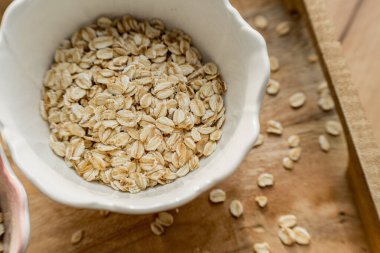 Ahşap kepçeli çiğ yulaf taneleri, renklendirme dokusu, tahıl yapısı ve sağlıklı doğal besin maddeleri..
