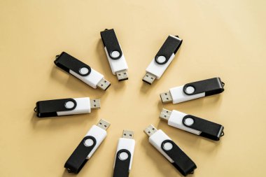 Nötr bej bir yüzeyde dairesel bir bileşime yerleştirilmiş çoklu USB flash diskler taşınabilir veri depolama ve dijital teknolojiyi temsil ediyor..