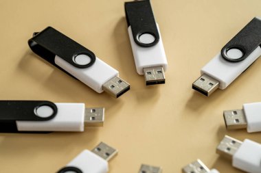 Nötr bej bir yüzeyde dairesel bir bileşime yerleştirilmiş çoklu USB flash diskler taşınabilir veri depolama ve dijital teknolojiyi temsil ediyor..