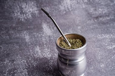 Kurumuş yerba mat yapraklarını Bombilla 'lı bir palo santo materyali ile kapatıyoruz. Koyu dokulu arka planda doğal bitkisel karışım, geleneksel Güney Amerika içkisi ve sağlıklı yaşam tarzı konsepti.