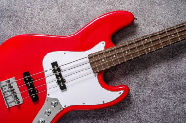 Nötr dokulu arka planda görünen fretboard ve başlıklı kırmızı elektro gitarın ayrıntıları. Müzik aleti konsepti, rock and funk sound, stüdyo kapanıyor..