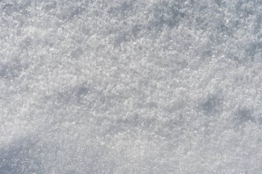 Yumuşak ışık ve ince gölgelerle doğal kar yüzeyi dokusu. Kopya alanı olan kış arkaplanı, en az mevsimlik arkaplan.