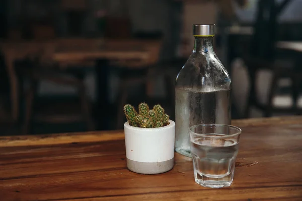 Dricksvatten. Glas med en flaska på bordet Stockfoto