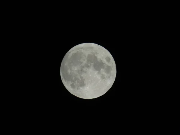 Genova, Italy - 09/25/2020: An amazing photography of the full moon over the city of Genova by night with a great clear sky in background and some stars