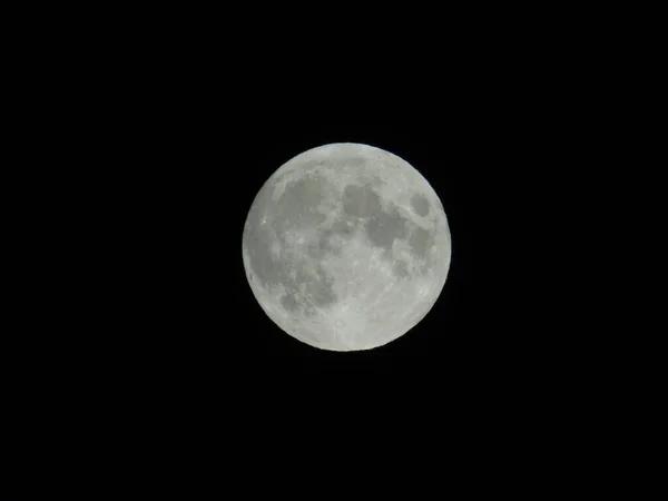 Genova, Italy - 09/25/2020: An amazing photography of the full moon over the city of Genova by night with a great clear sky in background and some stars