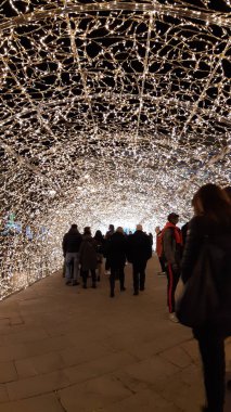 Cenova, İtalya - 12 / 02 / 2020: Cenova sokaklarında kış aylarında sanatsal bir geçmişe sahip muhteşem bir Noel süslemesi ışıkları ve o anı birleştiren bazı insanlar