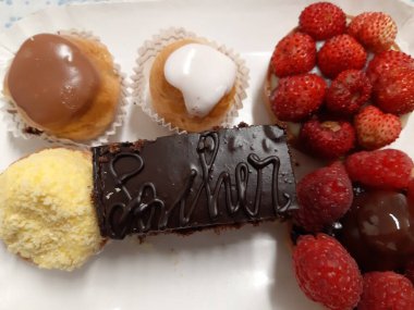 Cenova, İtalya - 5 Mart 2021: Renkli pastalar ve taze meyveli tatlılarla dolu tabanın güzel fotoğrafları.