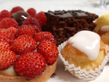 Cenova, İtalya - 5 Mart 2021: Renkli pastalar ve taze meyveli tatlılarla dolu tabanın güzel fotoğrafları.