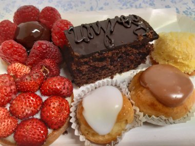 Cenova, İtalya - 5 Mart 2021: Renkli pastalar ve taze meyveli tatlılarla dolu tabanın güzel fotoğrafları.