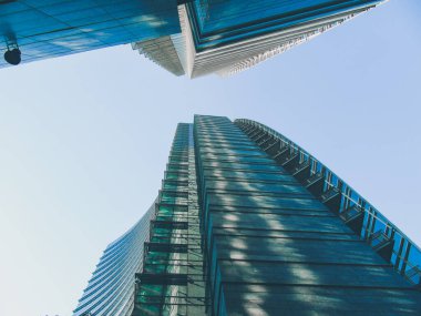 Milan, İtalya - 05 Mart 2021: Ofis ve gökdelenler parlak güneş ve açık mavi günbatımı arkaplanı. Ticari gayrimenkul. Modern iş şehri bölgesi. Dışarıdaki ofis binaları.. 