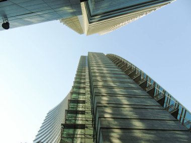 Milan, İtalya - 05 Mart 2021: Ofis ve gökdelenler parlak güneş ve açık mavi günbatımı arkaplanı. Ticari gayrimenkul. Modern iş şehri bölgesi. Dışarıdaki ofis binaları.. 