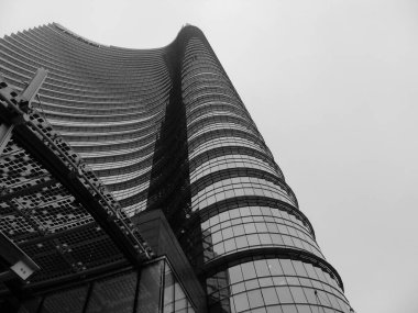 Milan, İtalya - 05 Mart 2021: Ofis ve gökdelenler parlak güneş ve açık mavi günbatımı arkaplanı. Ticari gayrimenkul. Modern iş şehri bölgesi. Dışarıdaki ofis binaları.. 