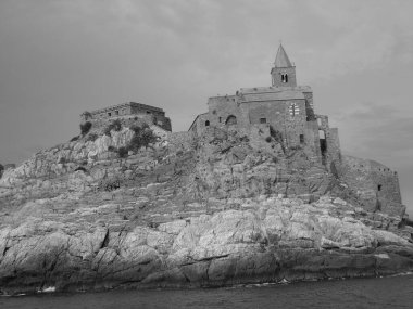 Ligurian sahilini geziyorum. Deniz kenarına ve eski köylere panoramik bir manzara. Gri gökyüzü olan ortaçağ renkli evlerin inanılmaz bir başlığı..