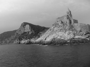 Ligurian sahilini geziyorum. Deniz kenarına ve eski köylere panoramik bir manzara. Gri gökyüzü olan ortaçağ renkli evlerin inanılmaz bir başlığı..
