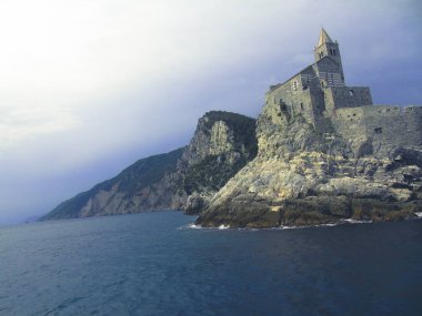 Ligurian sahilini geziyorum. Deniz kenarına ve eski köylere panoramik bir manzara. Gri gökyüzü olan ortaçağ renkli evlerin inanılmaz bir başlığı..