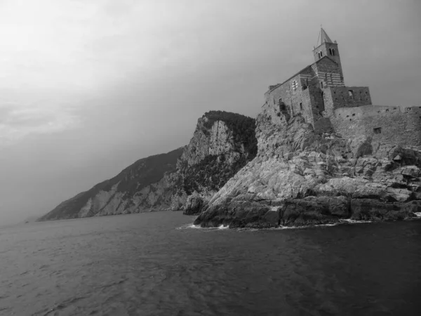 Ligurian sahilini geziyorum. Deniz kenarına ve eski köylere panoramik bir manzara. Gri gökyüzü olan ortaçağ renkli evlerin inanılmaz bir başlığı..