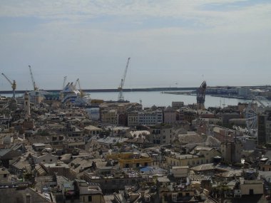 Cenova, İtalya - 09 Mayıs 2021: Cenova limanının panoramik manzarası, İtalya. Denizden eski kasabaya ve baharda güneşli bir günde limana bak. Cenova körfezi, liman, rıhtımda yat. Turizm beldeleri.