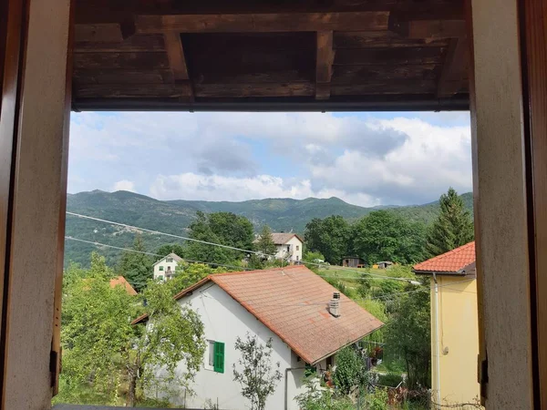 Genova, Italy - July 25, 2021: Beautiful view from the window to a small village\'s  landscape in summer days with grey sky in the background.