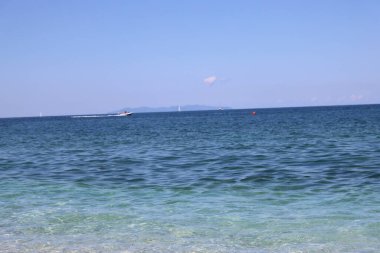 Capo Bianco (Elba), İtalya, 30 Ağustos 2021: Elba 'nın en ünlü plajından yaz günlerine kadar panoramik manzara. Güzel mavi gökyüzü berrak suyun üzerinde yansıyor..