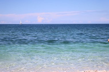 Capo Bianco (Elba), İtalya, 30 Ağustos 2021: Elba 'nın en ünlü plajından yaz günlerine kadar panoramik manzara. Güzel mavi gökyüzü berrak suyun üzerinde yansıyor..