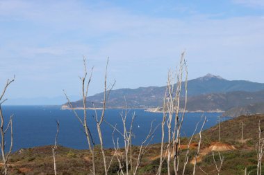 Elba, İtalya 01 Eylül 2021: Elba Adası 'ndan güzel yerler. Adanın havadan görüntüsü. Sahillerin yakınındaki küçük ünlü köyler. Yaz turistik yerleri. Arka planda bulutlar ve mavi gökyüzü.