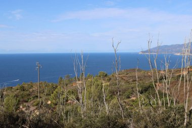 Elba, İtalya 01 Eylül 2021: Elba Adası 'ndan güzel yerler. Adanın havadan görüntüsü. Sahillerin yakınındaki küçük ünlü köyler. Yaz turistik yerleri. Arka planda bulutlar ve mavi gökyüzü.