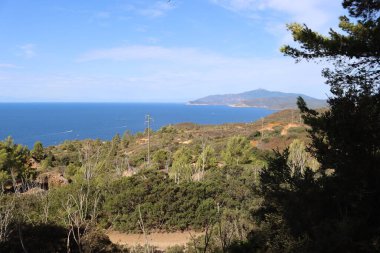 Elba, İtalya 01 Eylül 2021: Elba Adası 'ndan güzel yerler. Adanın havadan görüntüsü. Sahillerin yakınındaki küçük ünlü köyler. Yaz turistik yerleri. Arka planda bulutlar ve mavi gökyüzü.