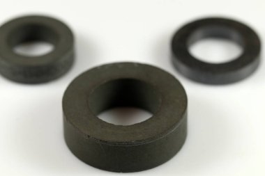 İndüktör yapmak için siyah ferrit halkaları. Çeşitli boyutlarda halkalar. Seçici odaklanma. Elektronik bileşenler.