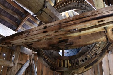 İçinde eski ahşap yel değirmeni var. Yel değirmeni tasarımı. Tahta bir şaftta büyük bir çark..