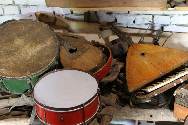 Old broken musical instruments. Drums, guitars and other musical instruments.