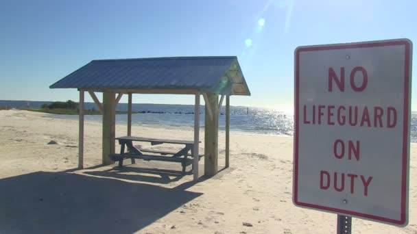 Picnic table and lifeguard sign at beach — Stock Video