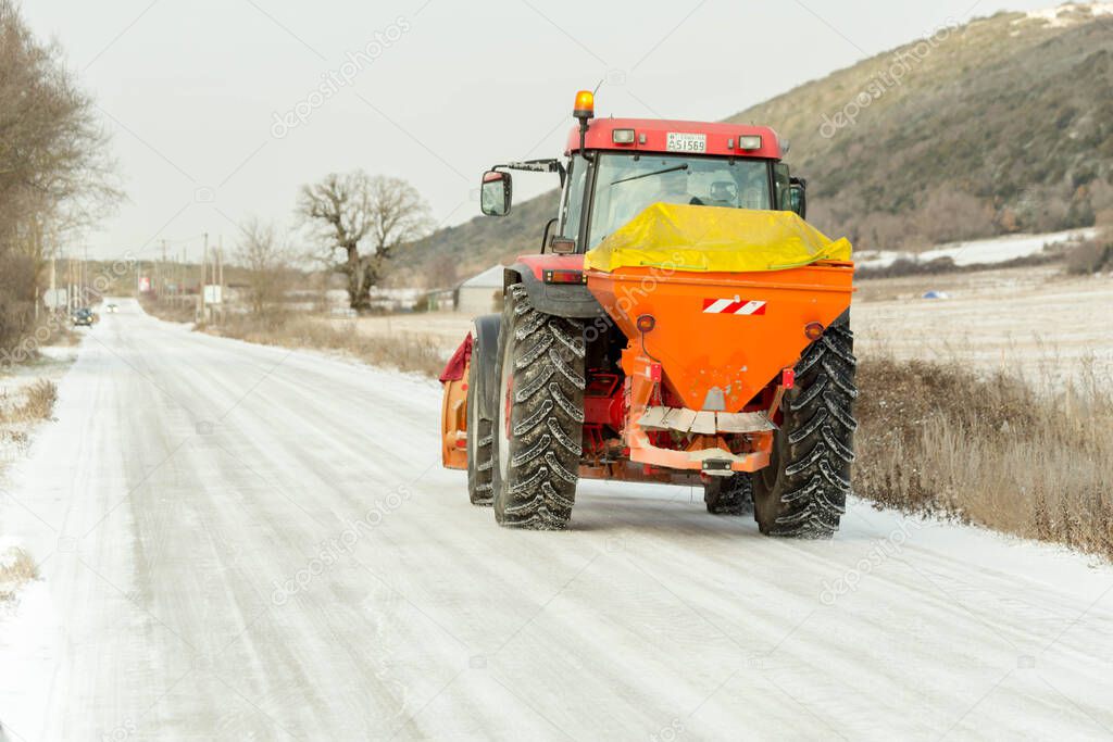 grader cleaning asphalt raod from ice and snow winter transportation problems background
