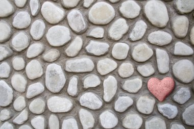 Kalp taşı, bir yerlerde beton bir kayanın içinde. Sevgililer günü arka planında. Kızıl bir aşık arama köşesini buldu. 