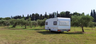karavan treyleri yaz mevsiminde deniz kenarında kumsal ağaçlarında mavi gökyüzü tatillerde seyahat eder