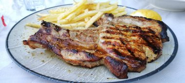 Patates ve mantarlı biftek ve tabakta tuz biberiyesi