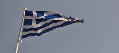 Yunan bayrağı rüzgarda ve güneşte dalgalanıyor