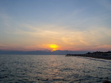 Antalya Türkiye kıyılarındaki denizin üzerindeki dağlarda muhteşem bir günbatımı. Yüksek kalite fotoğraf