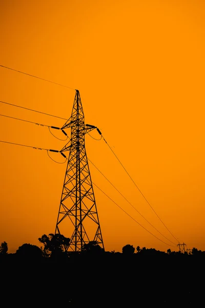 Torre de alimentación con electricidad de línea sobre fondo naranja — Foto de Stock