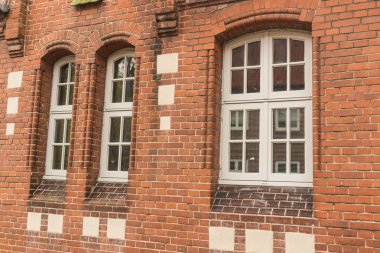 Geleneksel tuğla ve kereste kirişleri sergilenen klasik bir Fachwerk evinin önünde bir sıra park edilmiş araç. Sakin meskun sokaklar, miras mimarisi ve modern yaşamın bir karışımını yansıtıyor..