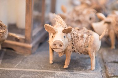 Kaprisli, el yapımı, saman aksanlı ahşap bir domuz heykelciğinin yakın çekimi. Geleneksel Noel ya da Alman pazarındaki uğurlu hatıra.