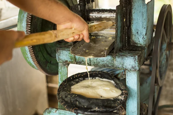 Extraindo o suco de cana de açúcar com a velha máquina tradicional — Fotografia de Stock