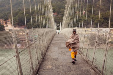 Rishikesh, Hindistan - Ocak: Tanımlanamayan yaşlı bir inci üzerinde yürüyen adam
